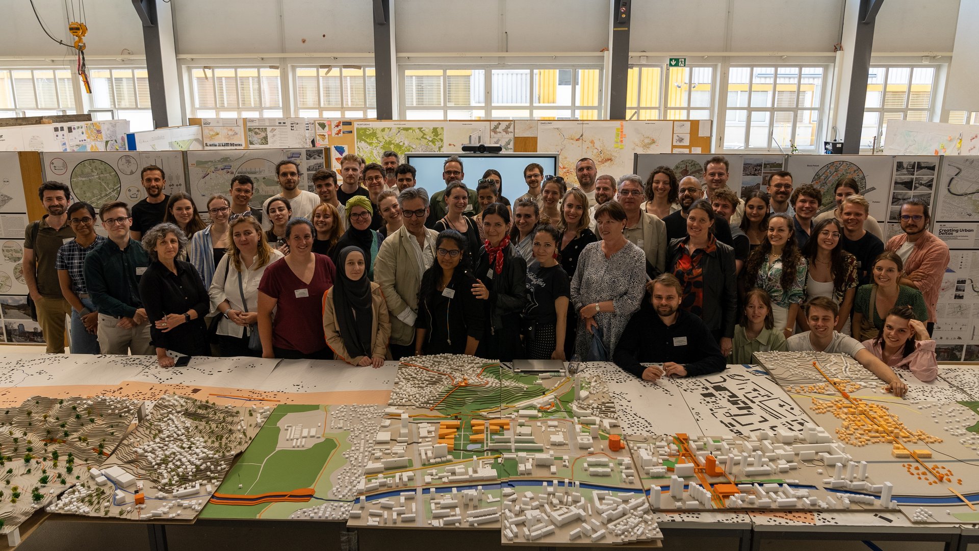 Participants stand in front of the physical model of the city during the design studio in Sarajevo 2023.